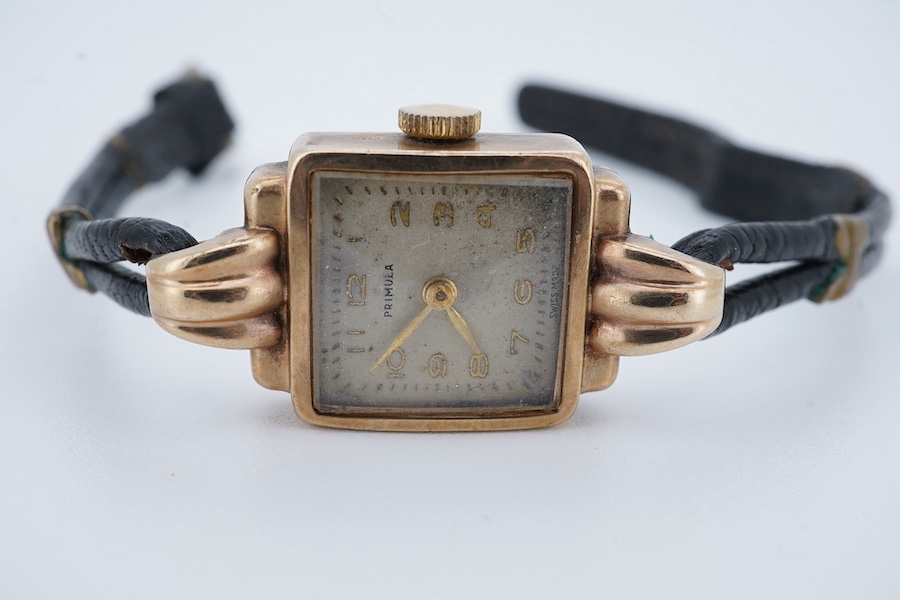 A lady's 9ct gold Primula manual wind wrist watch, with fluted lugs, on a leather strap. Condition - fair